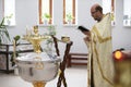 The priest reads a prayer before the baptism of the child.