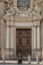 A priest reads seated in front of the Parish Church of Santissima Annunziata in Parma, Italy