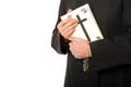 Priest's hands on bible with rosary