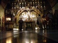 A priest and several faithful inside the Church of the Holy Sepulcher of Jesus Christ in the city of Jerusalem, Israel