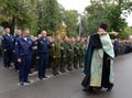 The priest sprinkles with holy water the cadet before academic year.