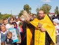 Priest sprinkling holy water on people