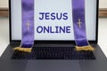 Priest stole across the laptop screen with message Jesus online