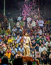 Priest throwing flower petals during Ganga aarti on banks of holy river Ganges in one of the oldest living cities of World and