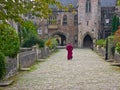 Priest walking through cloisters Wells