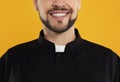 Priest wearing cassock with clerical collar on yellow background, closeup Royalty Free Stock Photo