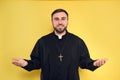 Priest wearing cassock with clerical collar on yellow background Royalty Free Stock Photo