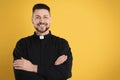 Priest wearing cassock with collar on yellow background, space for text Royalty Free Stock Photo