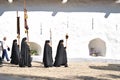 Priests at a ceremony walking with cross and other symbols