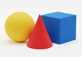 Primary colored geometric shapes including sphere cone and cube on a plain surface Royalty Free Stock Photo