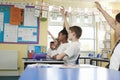 Primary school children raising hands in class, low angle Royalty Free Stock Photo