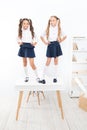 Primary school fashion. Happy school kids with fashion look standing on table. Fashion small girls with long hair