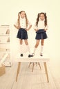 Primary school fashion. Happy school kids with fashion look standing on table. Fashion small girls with long hair