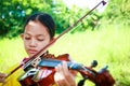 Primary school girl Playing the violin in the garden. Royalty Free Stock Photo