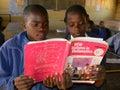 Primary school girls reading Mathematics textbook in class