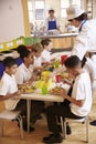 Primary school kids eat lunch in school cafeteria, vertical Royalty Free Stock Photo