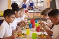 Primary school kids eating at a table in school cafeteria Royalty Free Stock Photo