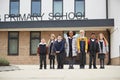 Primary school kids standing in front of their school looking to camera, full length, low angle Royalty Free Stock Photo