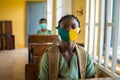 Primary school pupil`s sitting in class, wearing face masks, and observing physical distancing