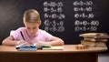 Primary schoolboy writing exercises in notebook, preparing homework, smart kid Royalty Free Stock Photo