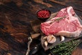 Prime T-bone beef meat steak, raw porterhouse steak on butcher board with herbs. Wooden background. Top view. Copy space Royalty Free Stock Photo