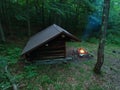 Primitive Bushcraft Adirondack lean to Shelter with campfire in the Wilderness. Royalty Free Stock Photo