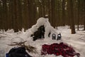 Primitive bushcraft shelter covered with snow.