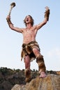 Primitive man standing on a rock