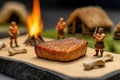 Primitive men miniature characters in process of cooking meat in nature Royalty Free Stock Photo