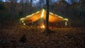 Primitive Tarp Shelter with campfire and fairy lights. Survival Bushcraft setup in the Blue Ridge Mountains near Asheville. During Royalty Free Stock Photo