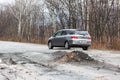 Primorsky Krai, Russia - 2016, autumn - A car drives along a bad, dead road among tall trees. Russian roads. Bad asphalt