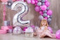 Princess baby girl celebrating life event wearing golden crown and pink airy dress. Cute girl posing in pastel colors studio shoot