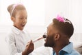 Princess black girl putting makeup on her queen father Royalty Free Stock Photo