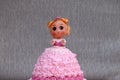 Princess doll cake with dress made of cream on grey background