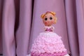 Princess doll cake with dress made of cream on pink curtain background