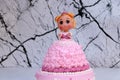 Princess doll cake with dress made of cream on marble pattern background