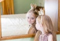 Princess little girl painting makeup lipstick on mirror