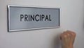 Principal office door, hand knocking closeup, visit to college chief, education