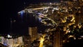 Principality of Monaco, brightly illuminated luxurious city at night aerial view