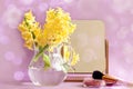 Pring is a time of good mood: a bouquet of yellow hyacinths, a mirror, powder and a brush on a pastel background, bokeh, space for