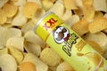 Pringles cheesy cheese flavour. Cardboard tube can on many Pringles potato chips background. Pringles is a brand of potato snack