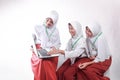 Three teenagers in SCHOOL uniforms smiling together using a laptop while carrying backpacks and books Royalty Free Stock Photo