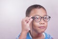 asian teenager holding nearsighted glasses. vision examination concept, eye fatigue, diagnosis