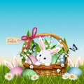 Three Easter bunny in grass with wicker basket and colorful eggs