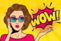 Pop art surprised female face. Comic woman in glasses with WOW! speech bubble. Retro pink dotted background.