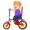 The boy is cycling on the colorful bicycle