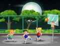 Happy boys playing basketball at the court in night Royalty Free Stock Photo