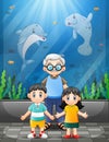 Grandfather and children watching sea animals in a giant aquarium