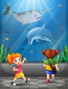 Happy kids looking at ocean fishes aquarium