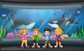 Funny school children looking at fish in aquarium Royalty Free Stock Photo